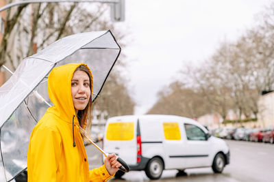 Woman holding umbrella in city