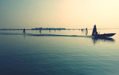 Silhouette person on sea against clear sky