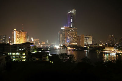 Illuminated buildings against sky at night