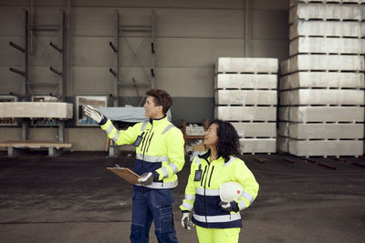 Female workers in protective workwear discussing at warehouse