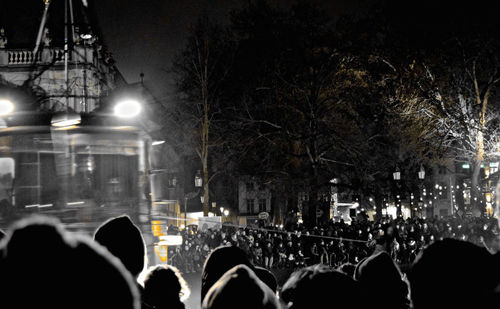 Crowd at illuminated city against sky at night