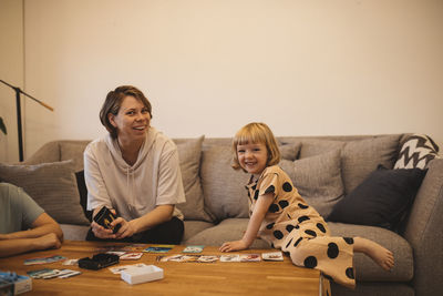 Smiling mother and daughters on sofa