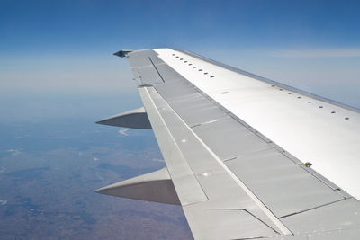 Airplane flying over clouds against sky