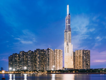 Modern buildings in city against sky at night