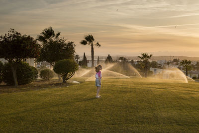 Rear view of woman playing soccer at park