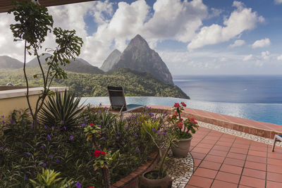Scenic view of sea by mountain against sky