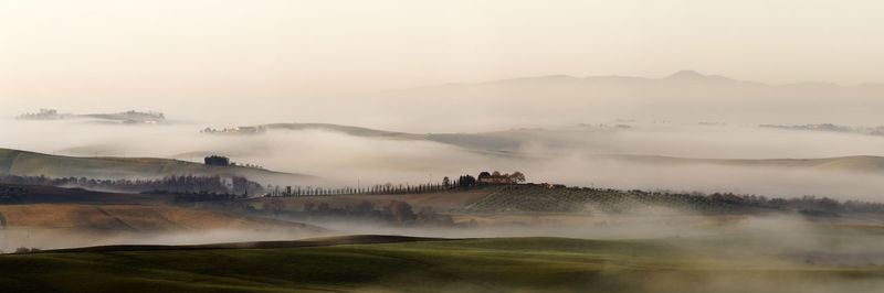 Scenic view of landscape against sky during foggy weather