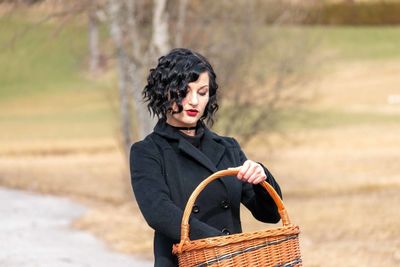 Portrait of young woman in basket on land