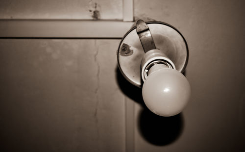 Close-up of light bulb hanging on wall