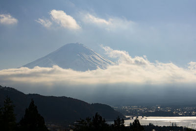 Scenic view of snowcapped mountains against cloudy sky