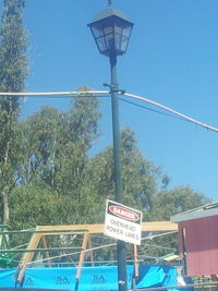 Low angle view of road sign against blue sky