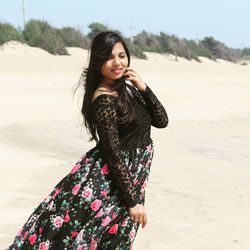 Smiling young woman standing on beach