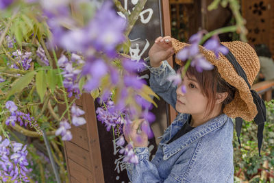 High angle view of woman looking at purple flowering plants