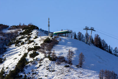 Snow covered land and mountains against clear blue sky