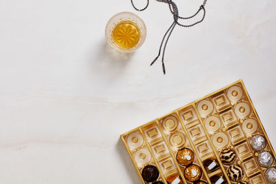 Still life with chocolate box, whiskey glass, necklace