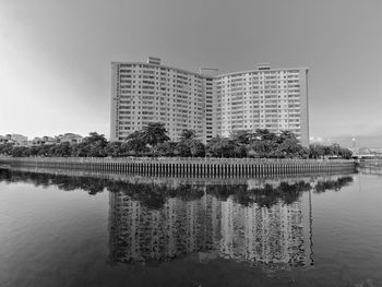 Reflection of building in lake against sky