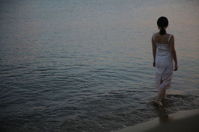 Rear view of woman standing on beach