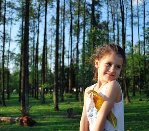 Cute little girl standing at park on sunny day