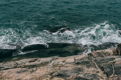 High angle view of waves splashing on rocks