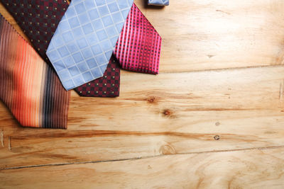 High angle view of colorful neckties on hardwood floor