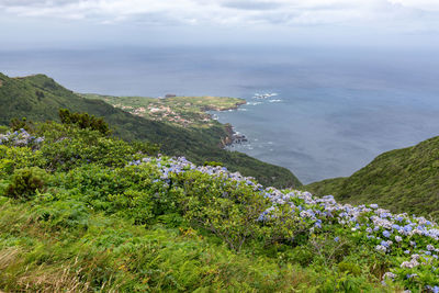 Scenic view of sea and mountains against sky