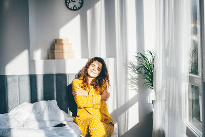 Young woman looking through window