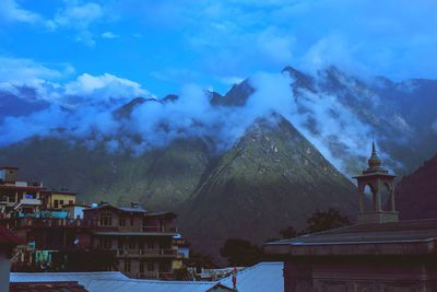 Buildings in city against cloudy sky