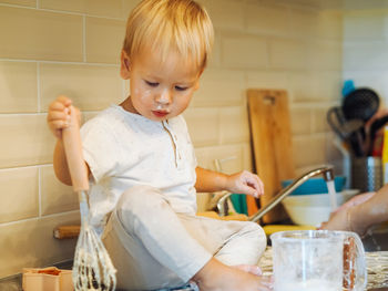 Cute boy preparing food at kitchen