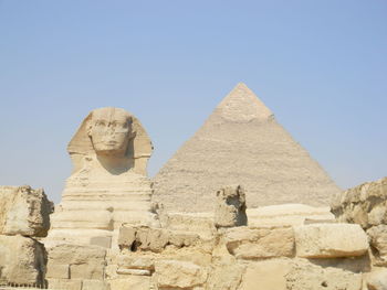 Sphinx and pyramide of gizeh against clear sky