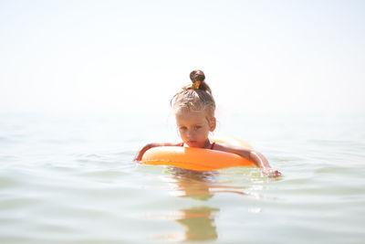 Portrait of boy swimming in sea against sky