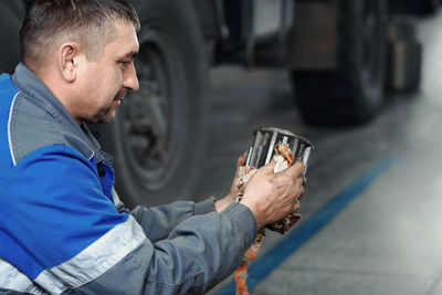 Side view of man holding car