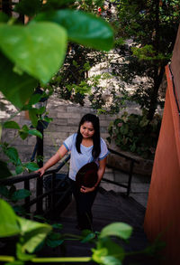 Portrait of woman standing against plants