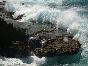 Scenic view of sea waves splashing on rock