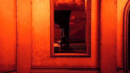 Woman standing by window of building