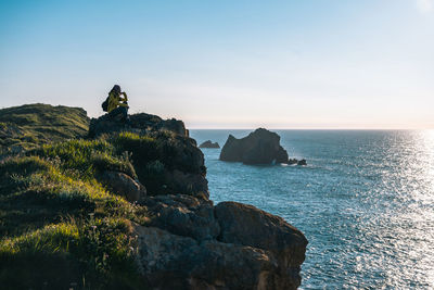 Asian girl sitting after hiking along the coast in spring during the sunset