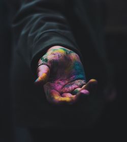 Close-up of human hand with colorful powder paint