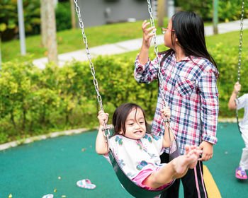 Rear view of women on swing at playground