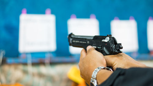 Cropped hands of man target shooting