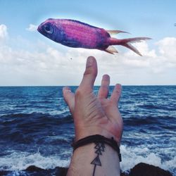 Cropped image of person standing by sea