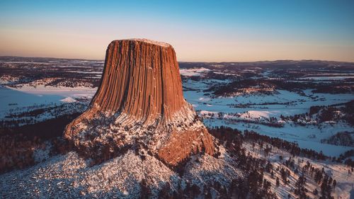 Aerial view of devils tower national monument against sky during sunset in winter
