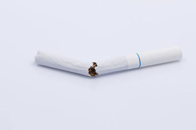 High angle view of broken cigarette on white background