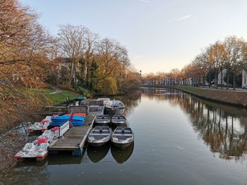 Boats moored in river against sky