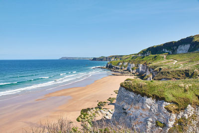 Scenic view of beach against blue sky