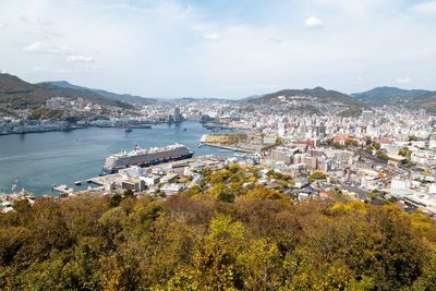 High angle view of townscape by sea against sky