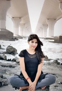 Portrait of young woman sitting on rock