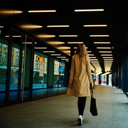 Rear view of woman walking on footpath