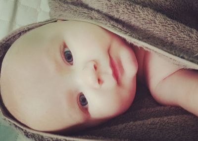 Close-up of baby girl lying in blanket