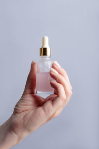 Cropped hand holding soap against white background