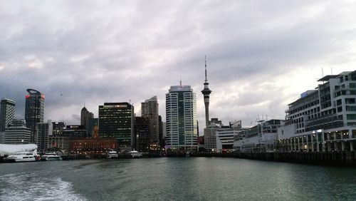 River amidst buildings in city against sky