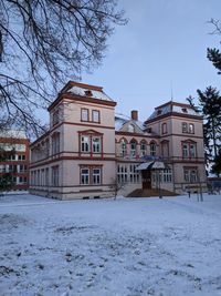 Snow covered houses and buildings against sky